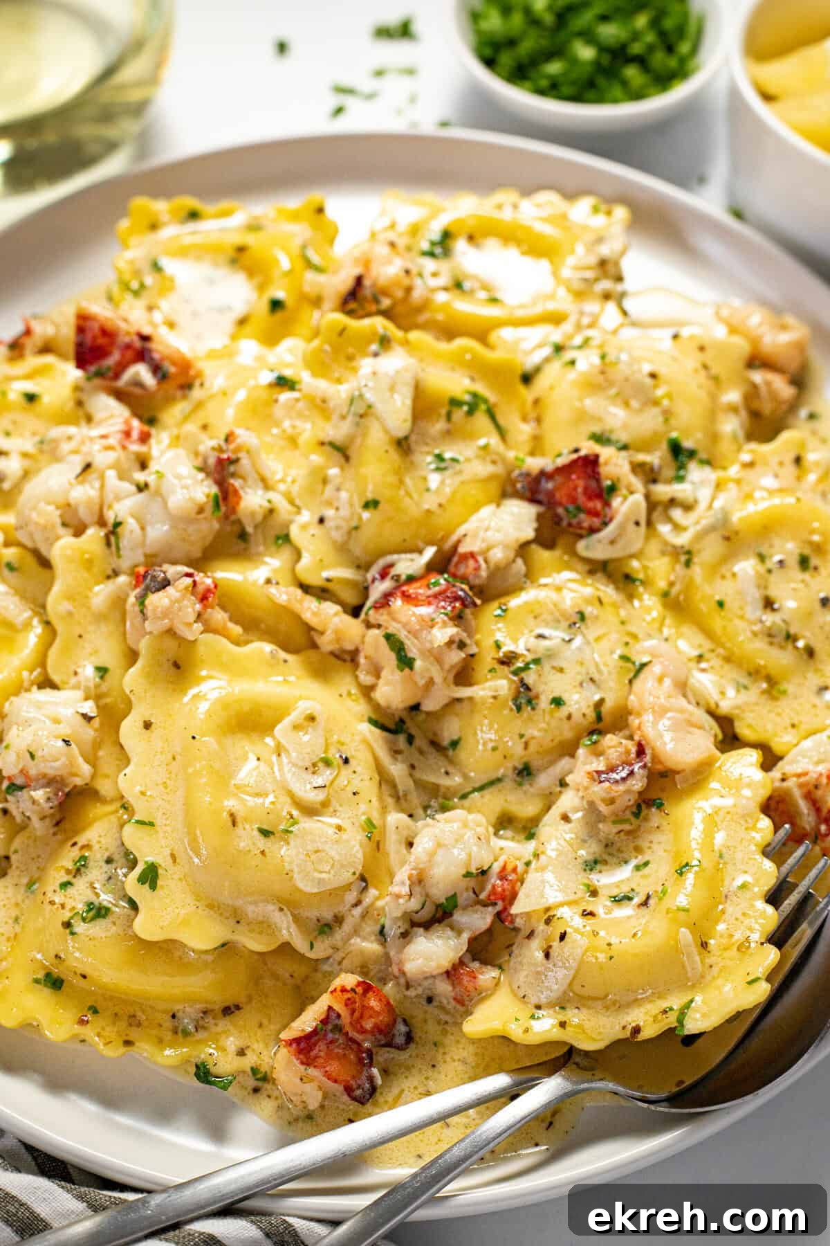 White plate filled with cheese ravioli and a creamy lobster ravioli sauce