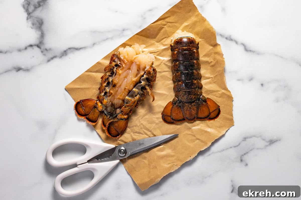 Two lobster tails on butcher paper with a pair of scissors next to them