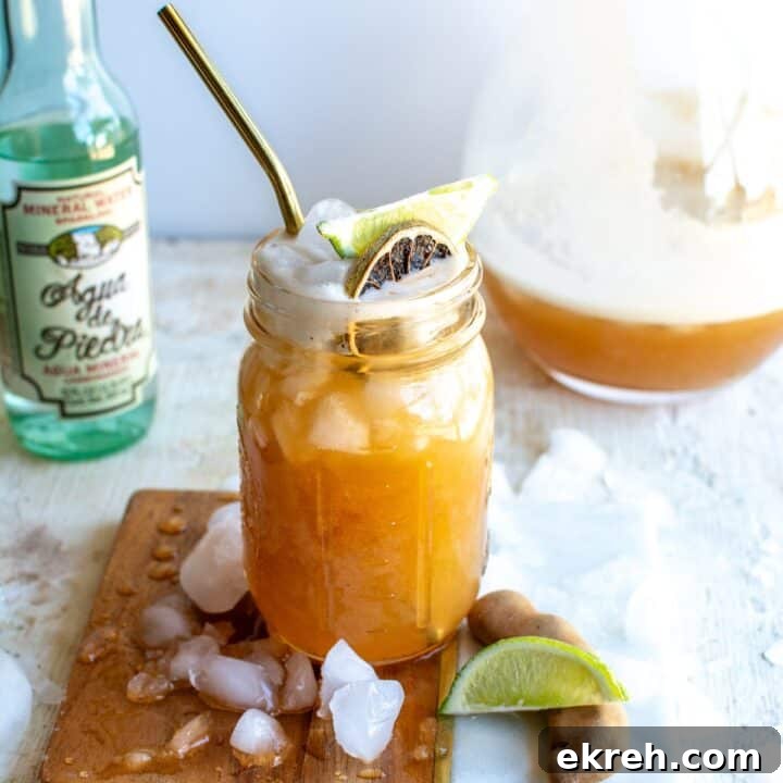 A glass of tamarind agua fresca with a lime garnish.