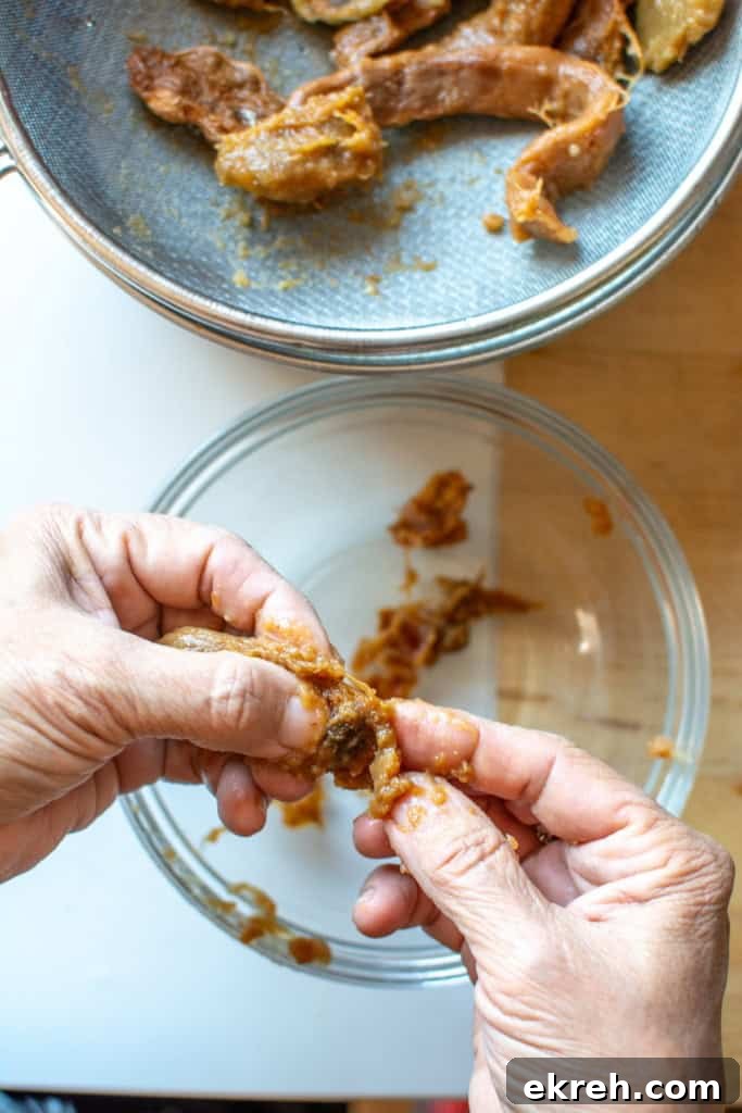 Tamarind Agua Fresca Recipe: Agua de Tamarindo 8 A hand picking out the seeds from the pulp.