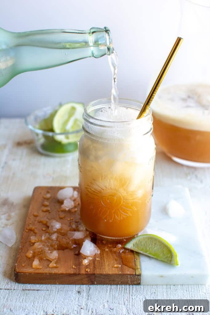 Tamarind Agua Fresca Recipe: Agua de Tamarindo 10 Sparkling water being poured into a glass of tamarind agua fresca