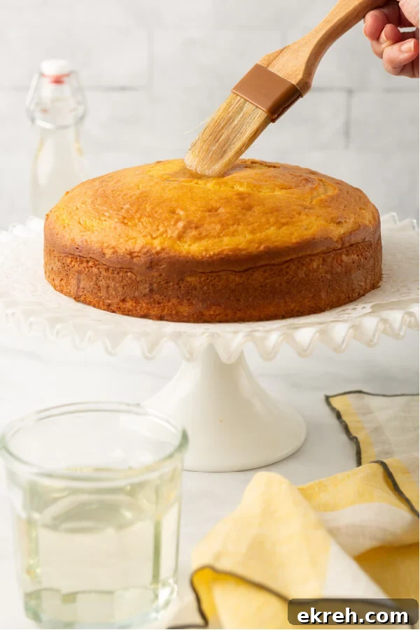 simple syrup being brushed onto baked cake layer