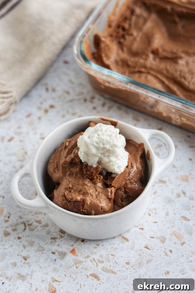 A cup of nice cream with coconut whip.