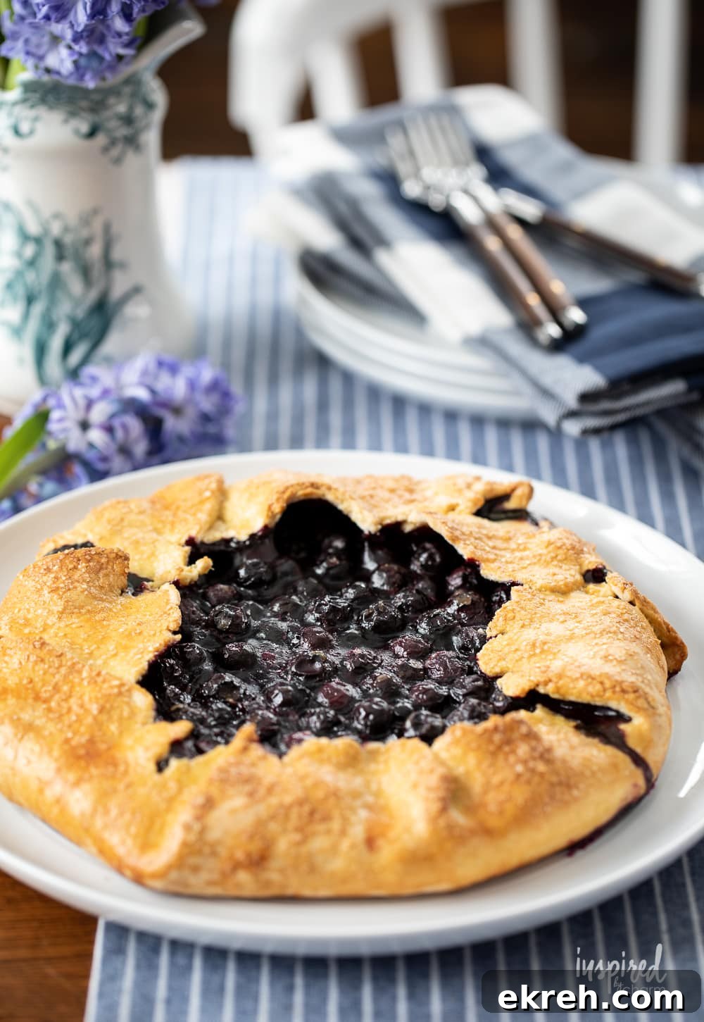 Blueberry Galette Recipe with Rustic Flaky Crust 3 whole blueberry galette on platter on table.