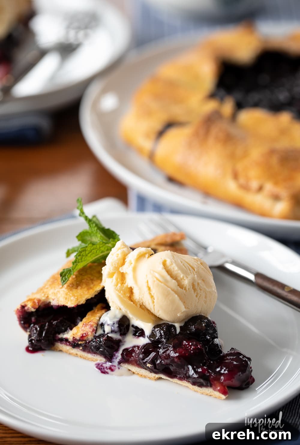 Blueberry Galette Recipe with Rustic Flaky Crust 8 slice of blueberry galette with ice cream on a plate.