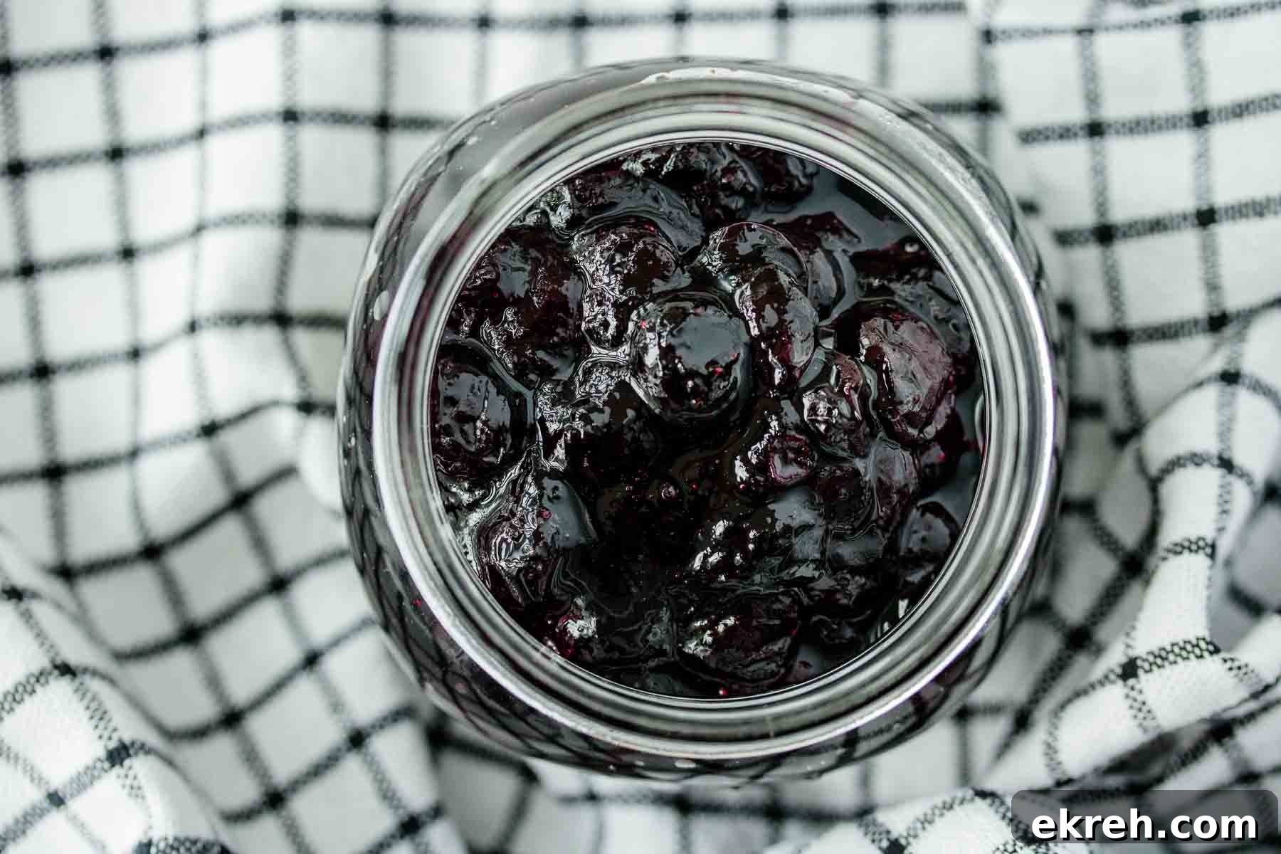 Blueberry Compote for Cheesecake Without Cornstarch 2 A jar of blueberry compote over a kitchen towel