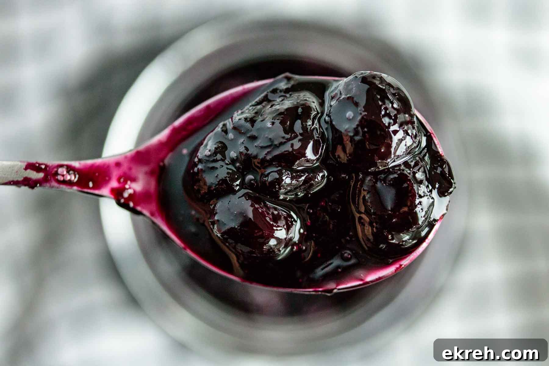 Blueberry Compote for Cheesecake Without Cornstarch 3 Close up of blueberry topping in a spoon