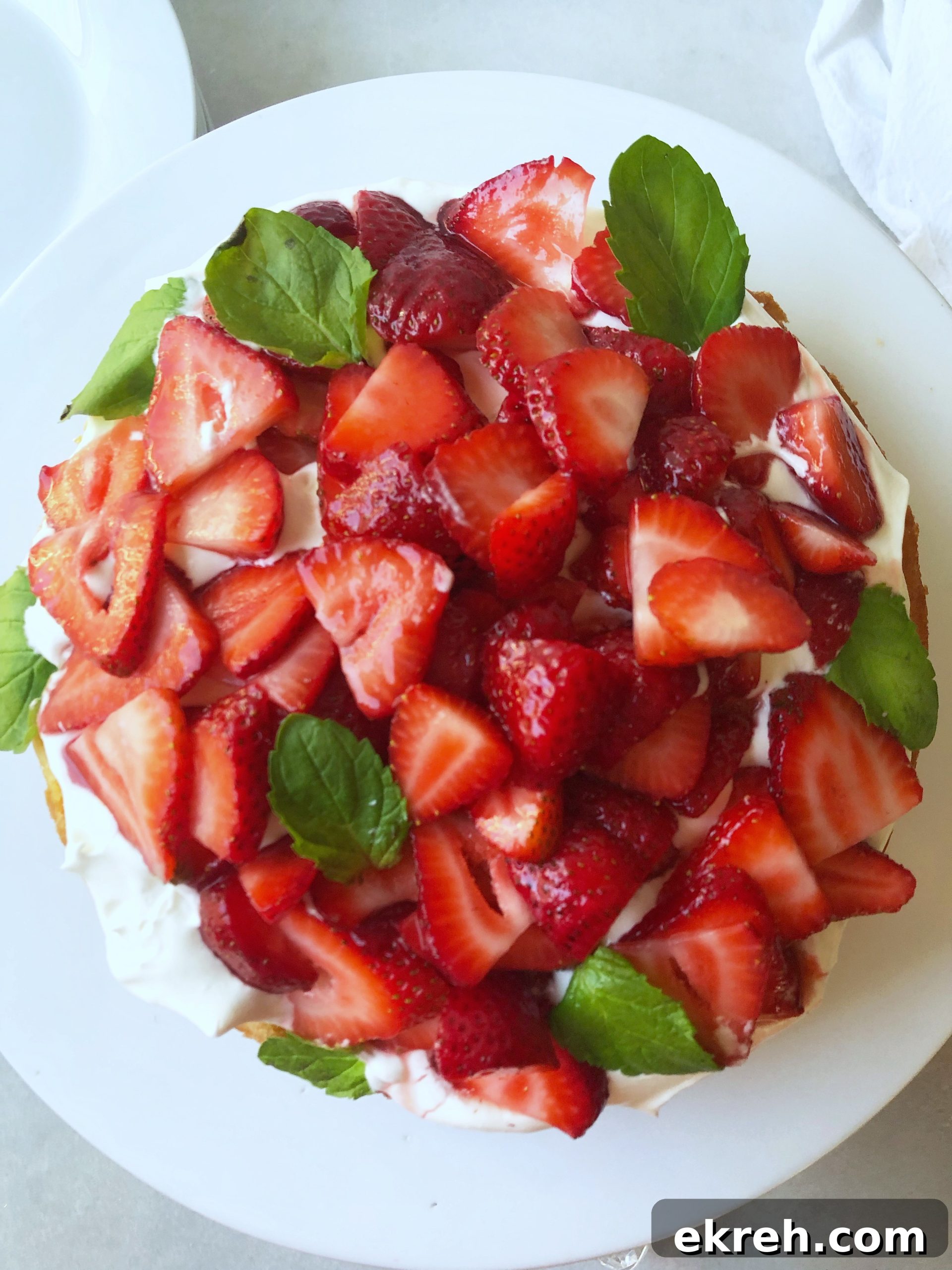 shortbread cake piled with fresh strawberries and whipped cream
