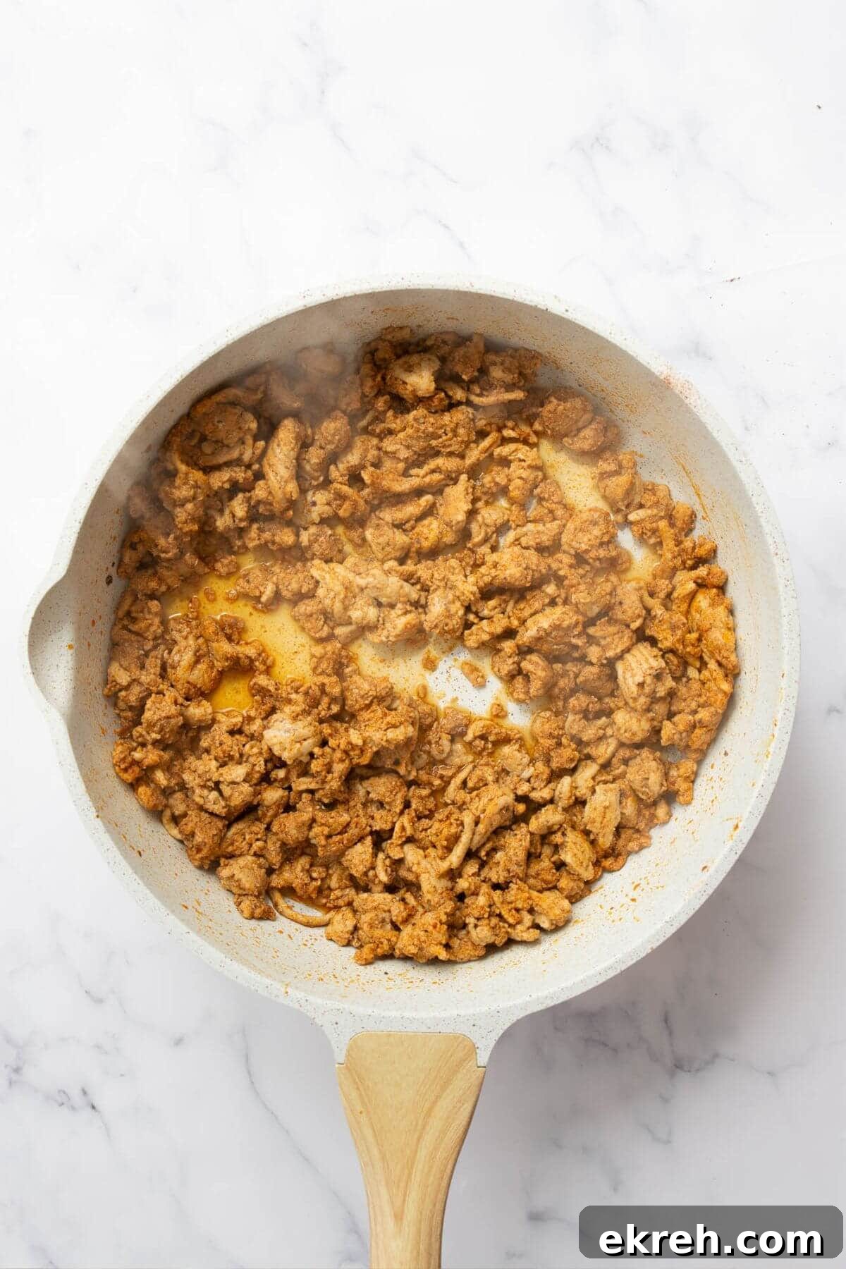 Cooked juicy and seasoned ground turkey in a pan.
