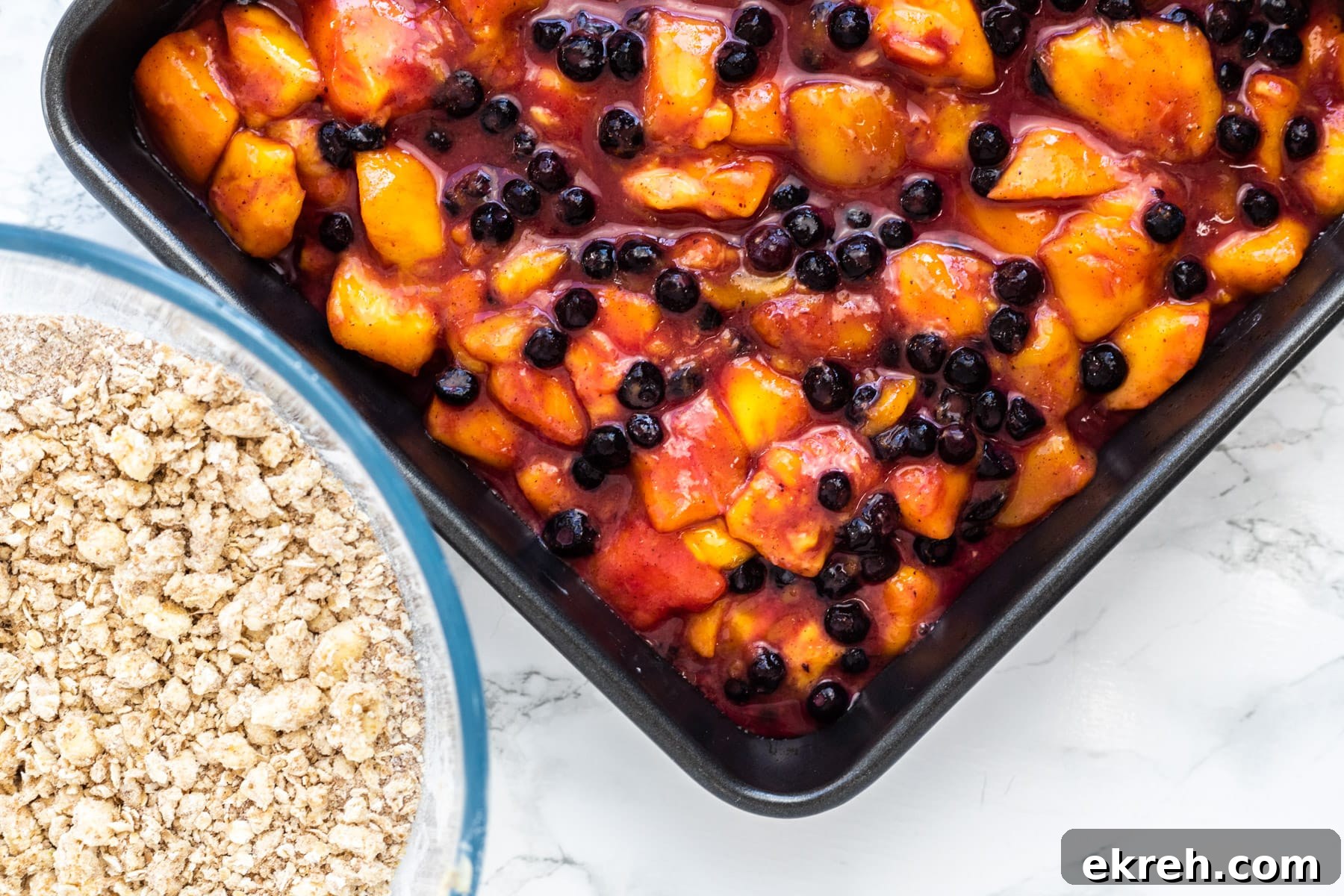 mango crisp filling in a baking idsh next to a bowl of crumble topping.