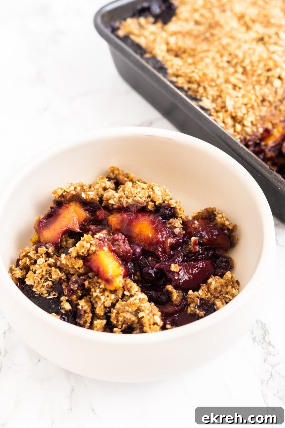 A side view of a bowl of chai mango blueberry crisp.