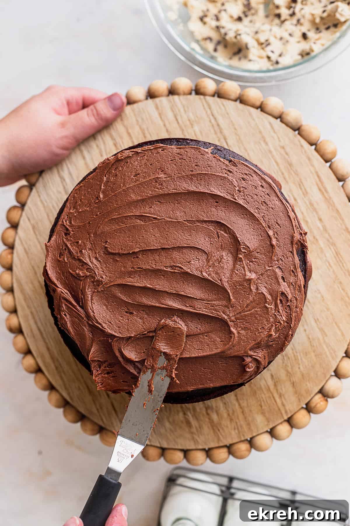 Spreading chocolate frosting on top of cake.