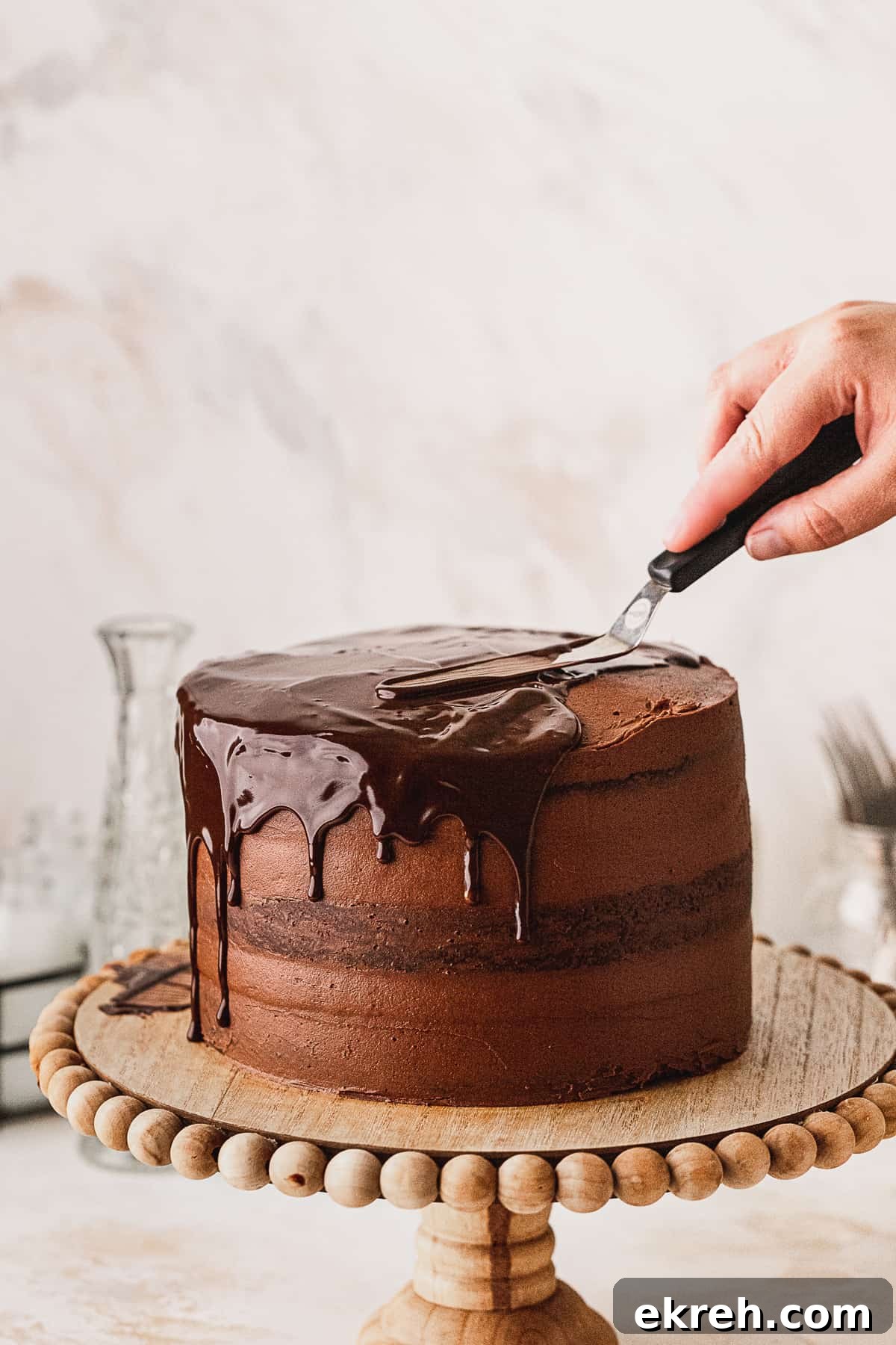 Spreading chocolate ganache on top of cake.