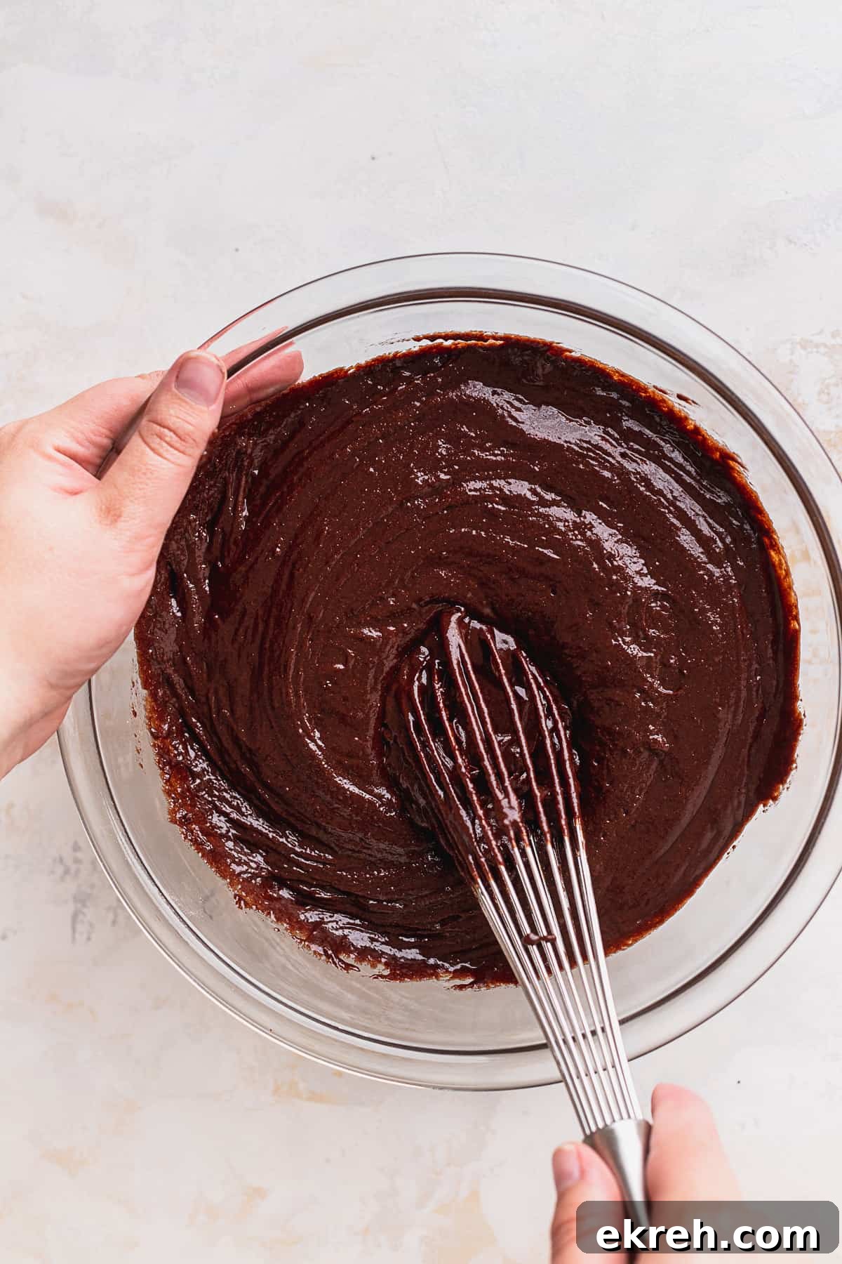 Mixing cake batter in a glass bowl.