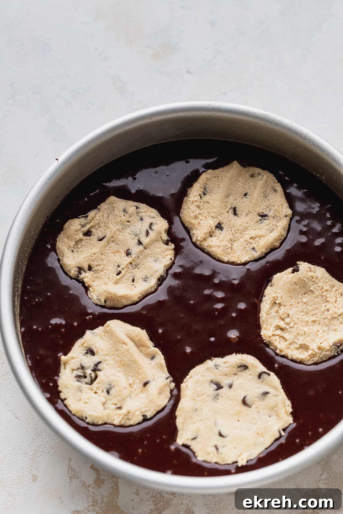 Cookie dough discs on top of cake batter.