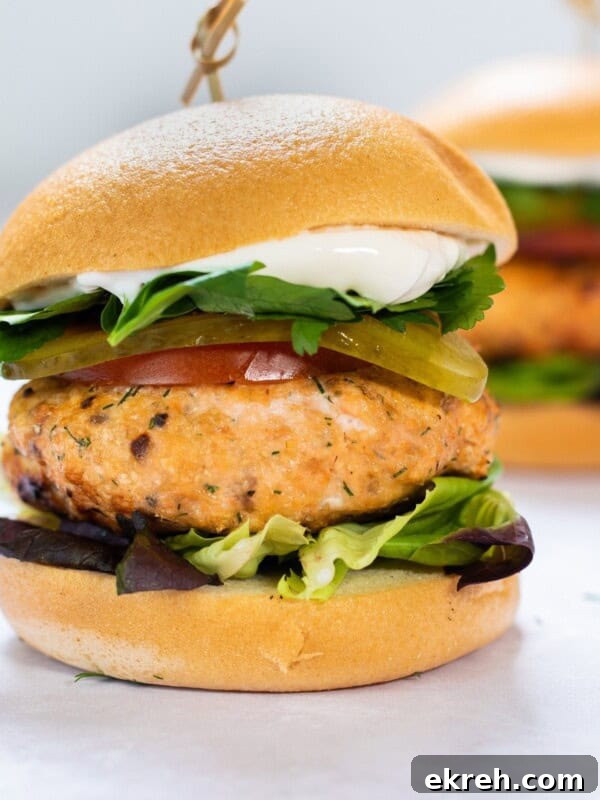 Salmon burger with bun and lettuce.