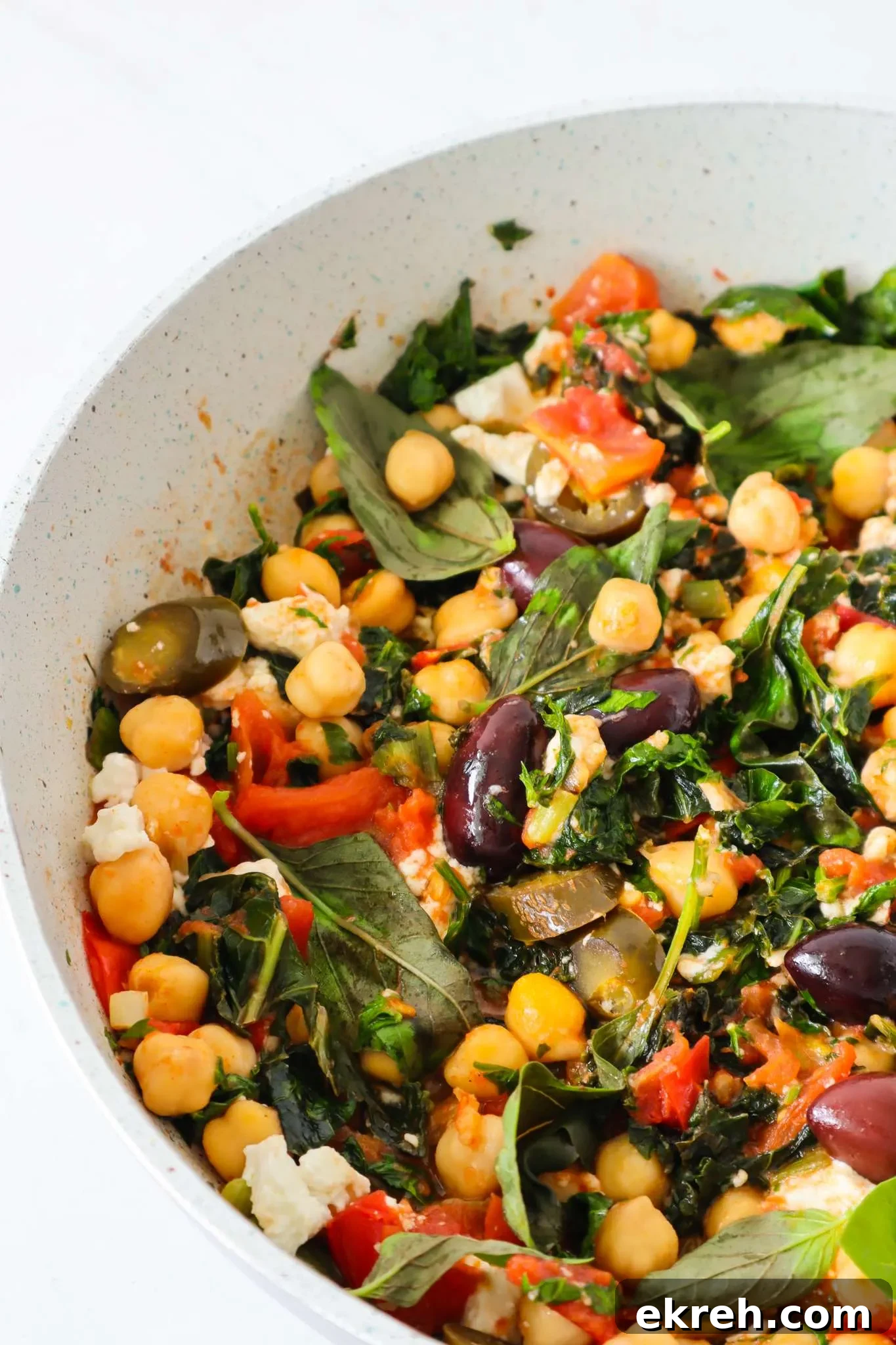 Serve Mediterranean chickpea skillet hot with fresh herbs and bread