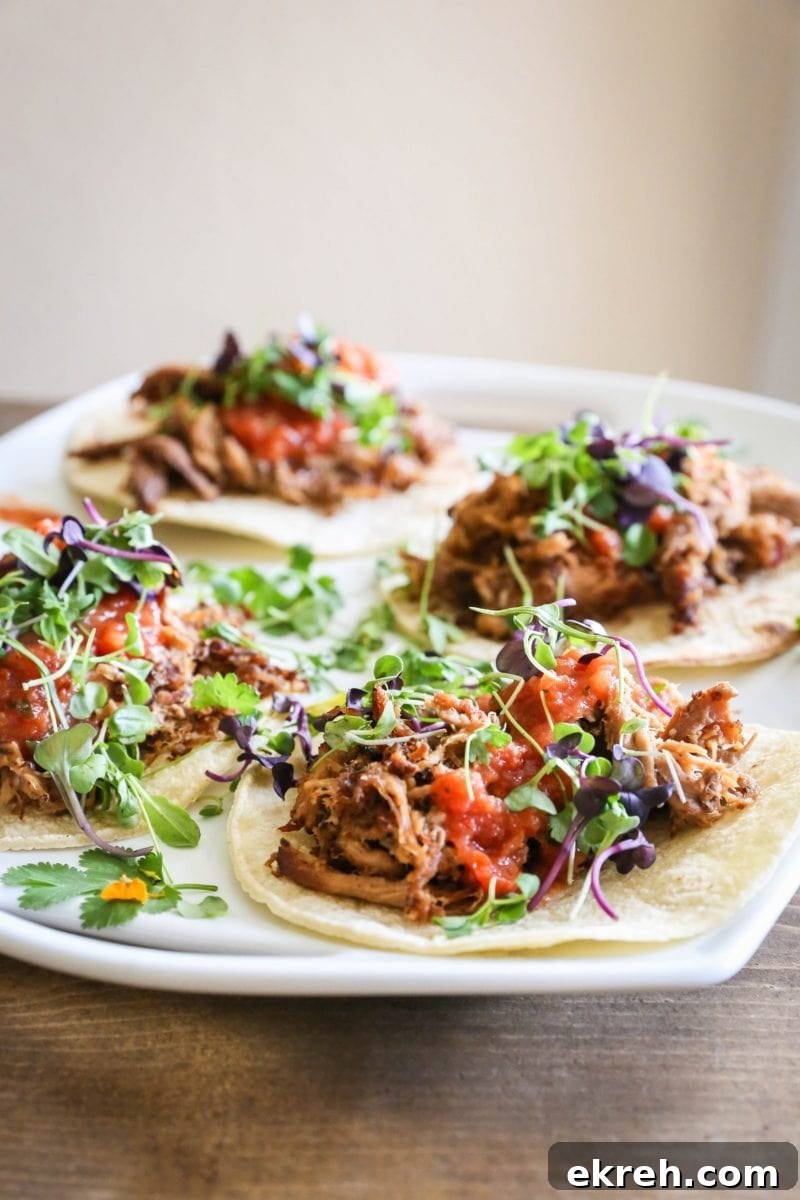 Close up platter of beef tacos with microgreens on top.
