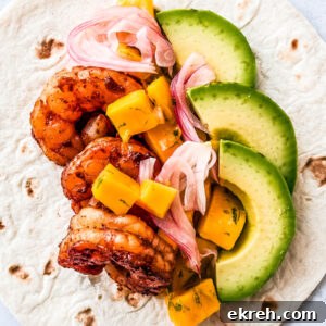 Flour tortilla topped with juicy shrimp, mango salsa, pickled onions, and avocado.