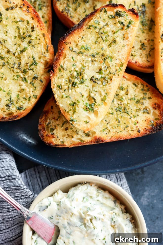 Crispy Sourdough Garlic Toast with Herb Butter 7 butter in bowl next to slices of sourdough garlic toast bread on a plate piled up