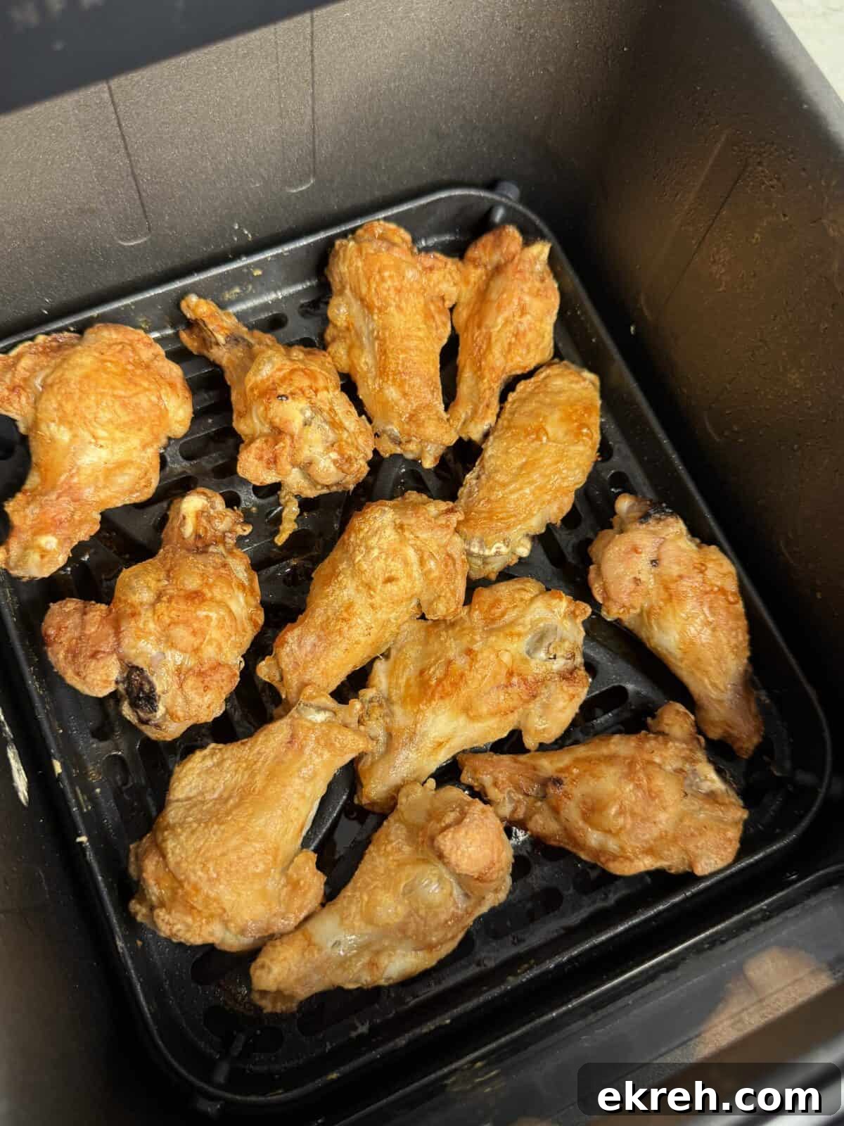 Close-up of wings coated in spicy ’nduja glaze with Parmigiano drizzle