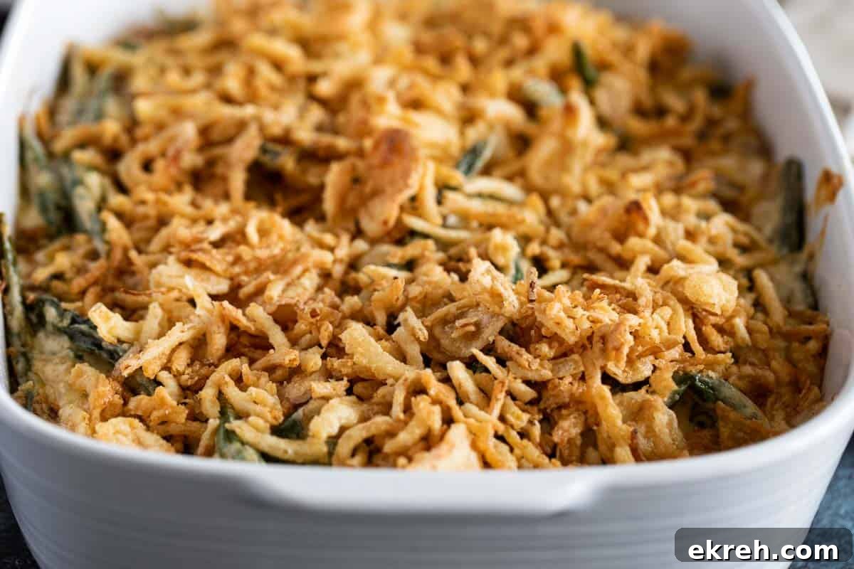 Casserole dish full of green bean casserole topped with crispy onions.