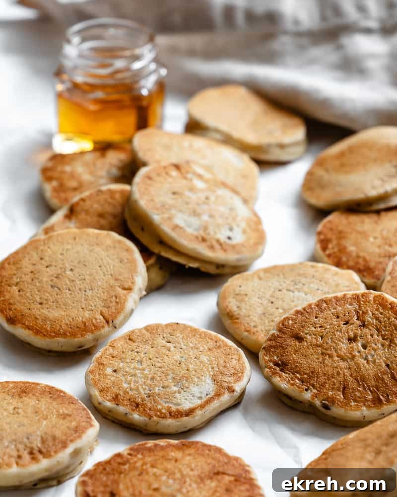 several completed Easy Vegan Pancakes [Regular or Mini] on a white surface 