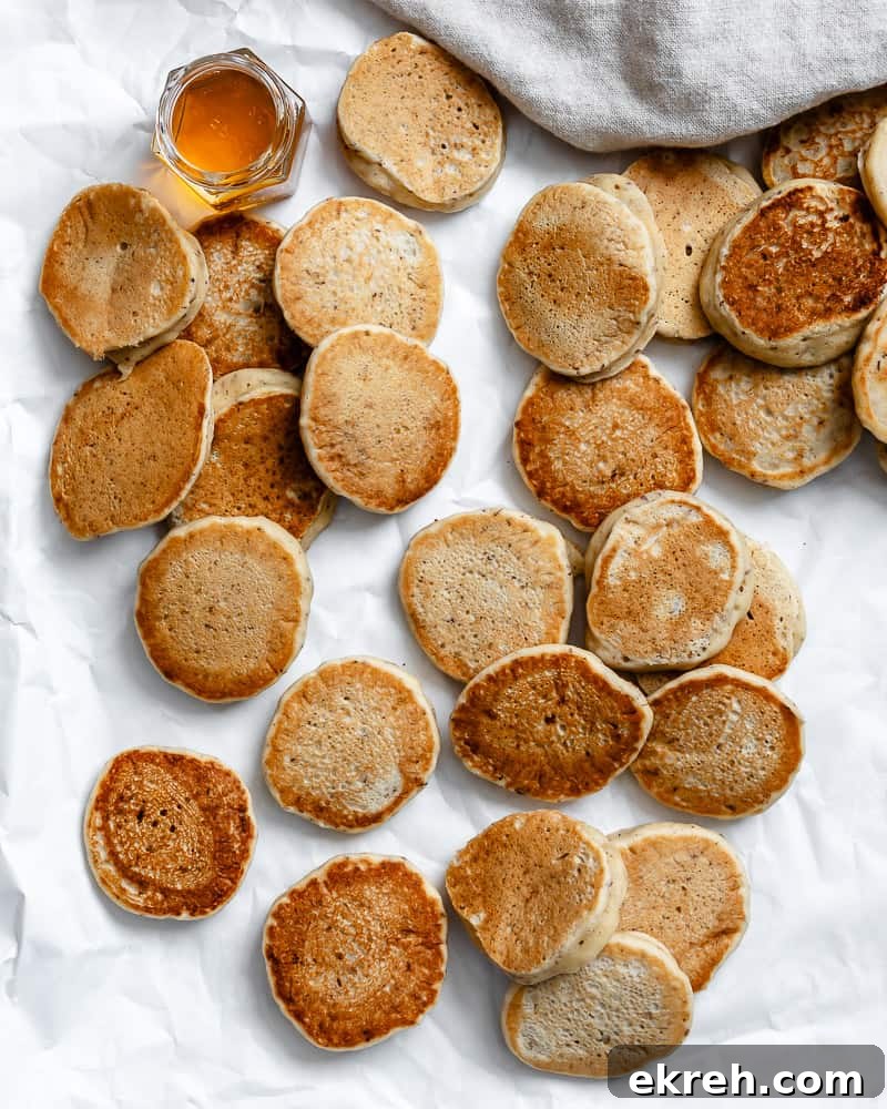 several completed Easy Vegan Pancakes [Regular or Mini] on a white surface