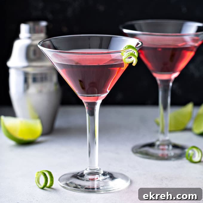 Two Cosmopolitan Martinis on a white surface
