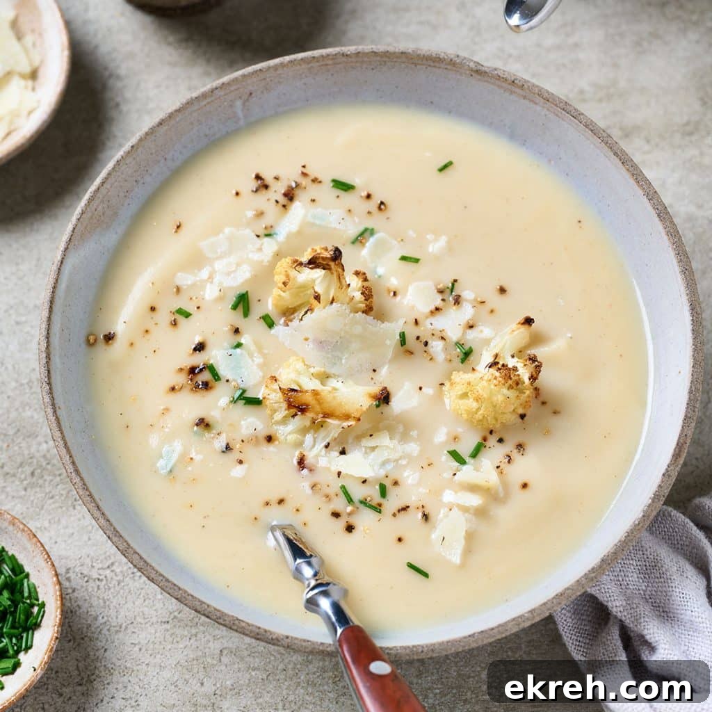 Top view of a creamy soup topped with pieces of roasted cauliflower