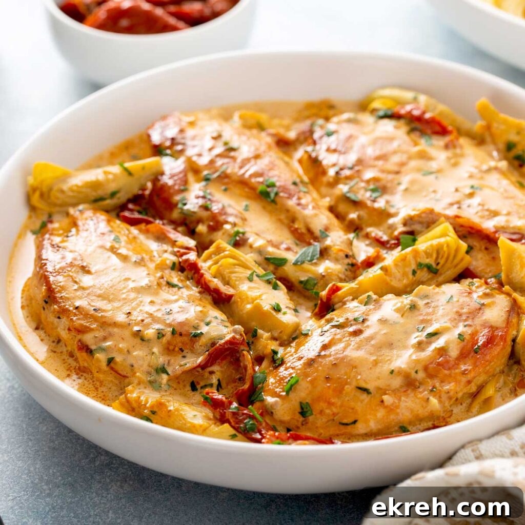 Chicken breast with sun dried tomatoes cream sauce in a white bowl