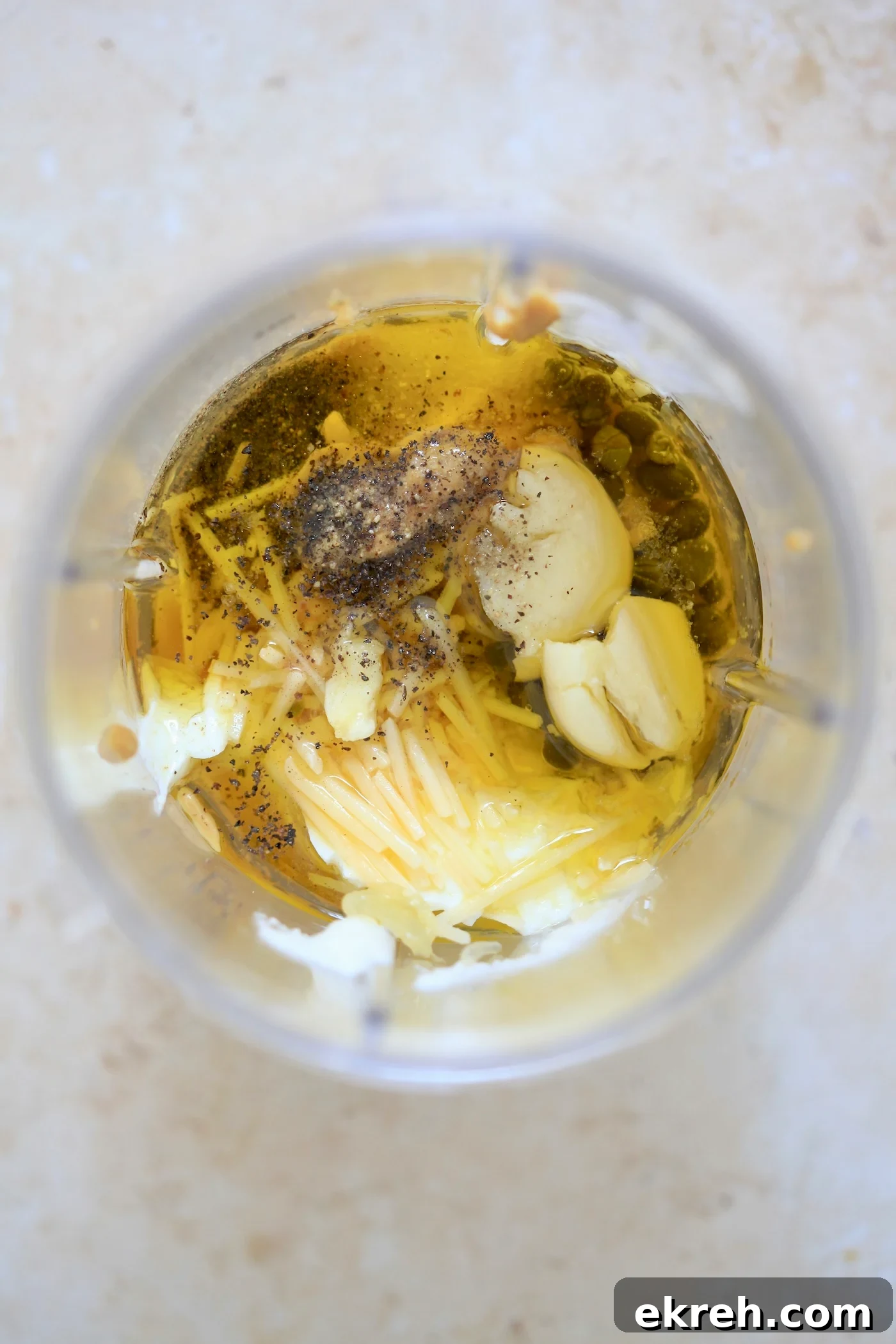 Yogurt, oil, garlic, and cheese in blender jar.