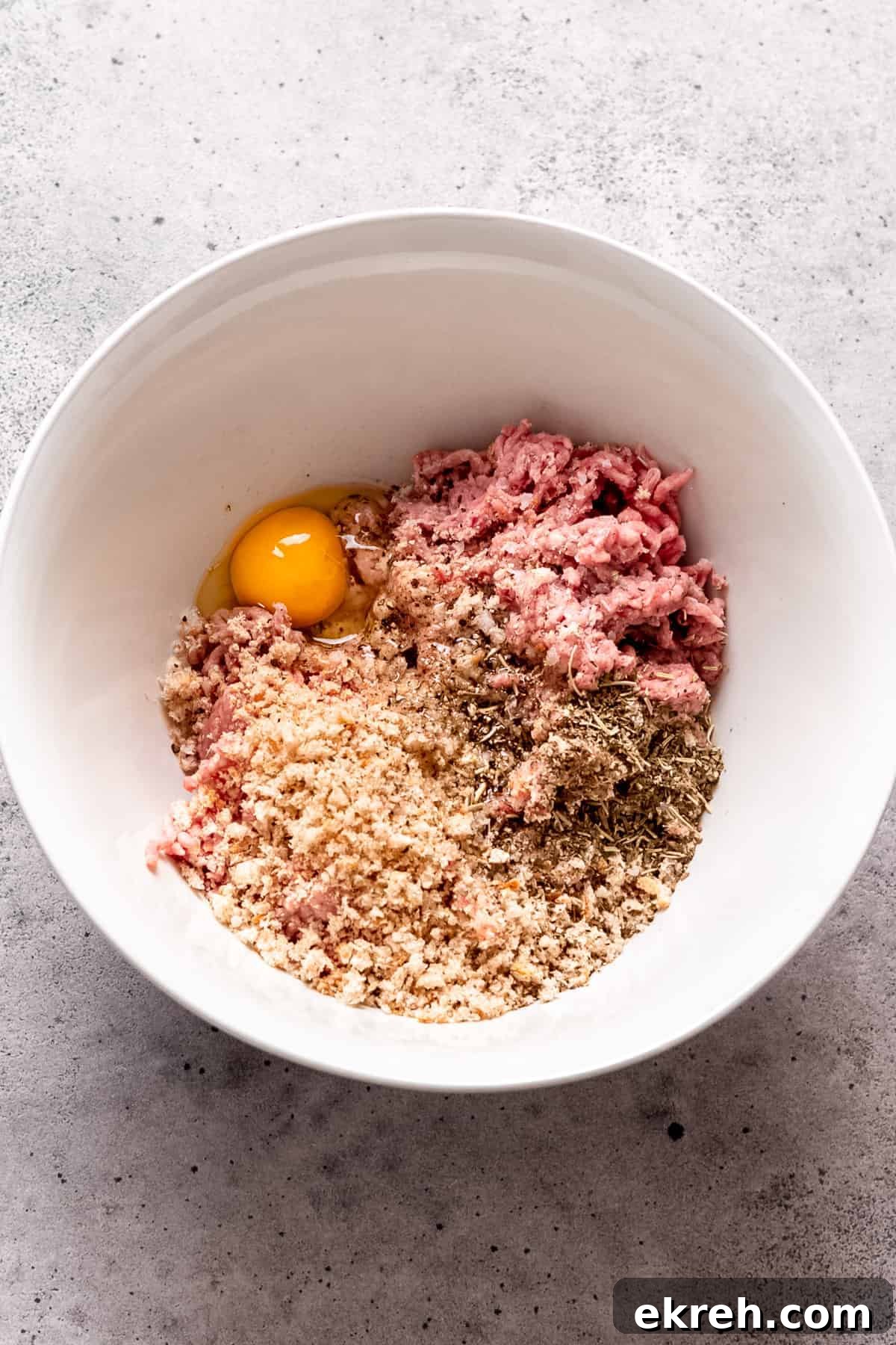 Classic Greek Chicken Meatballs with Tzatziki 3 Greek chicken meatball mixture in a bowl with breadcrumbs and egg.