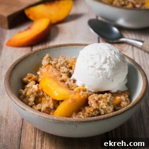 A bowl of gluten free peach crisp topped with vanilla ice cream.