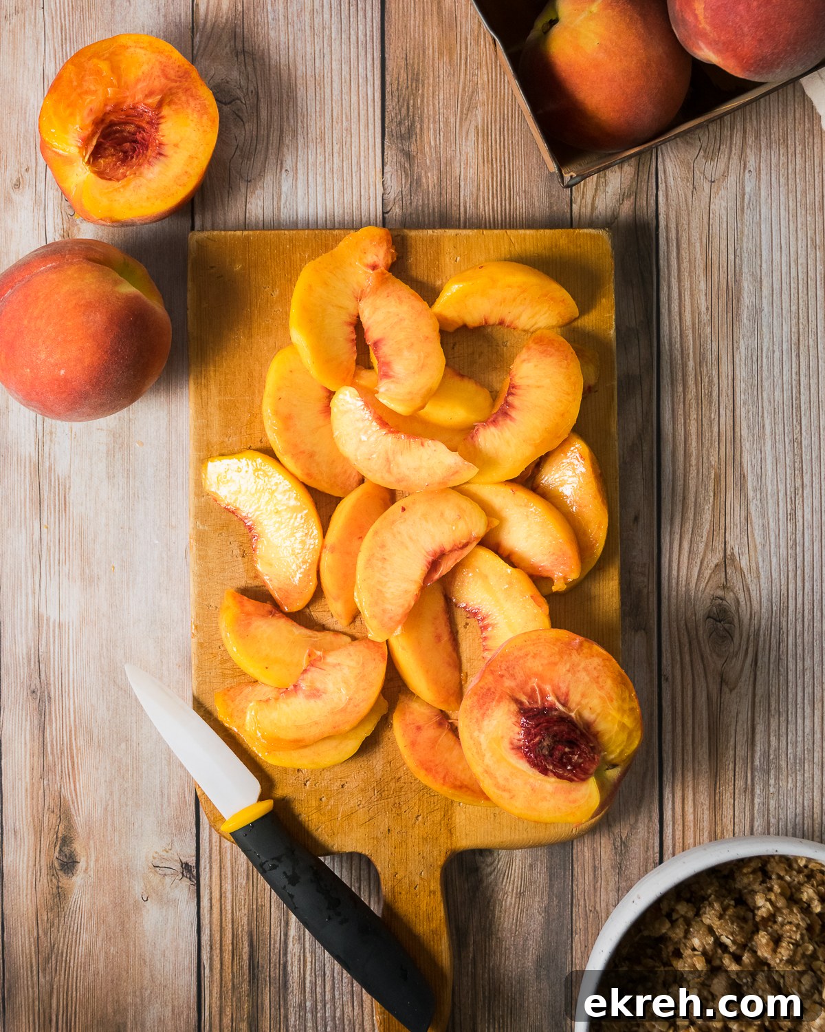 Sliced peaches on a wooden cutting board.