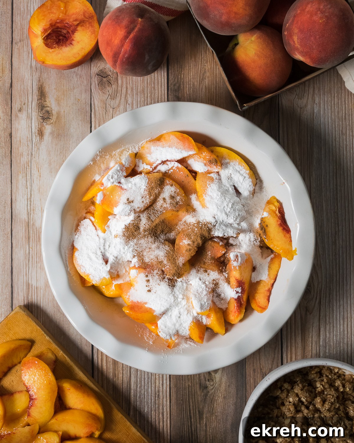 Sliced peaches in a baking dish topped with flour and spices.