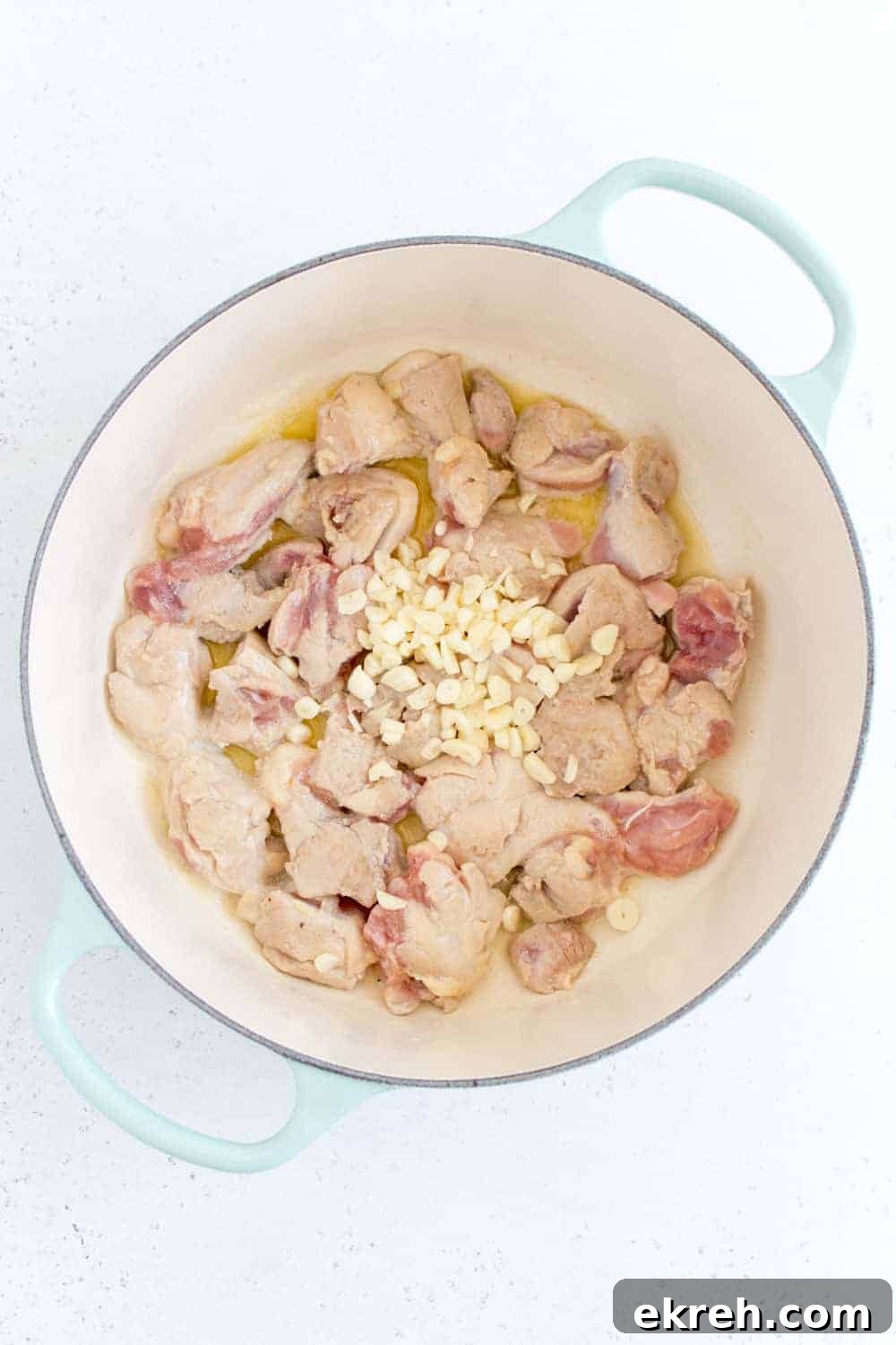 minced garlic added to chicken thighs in dutch oven