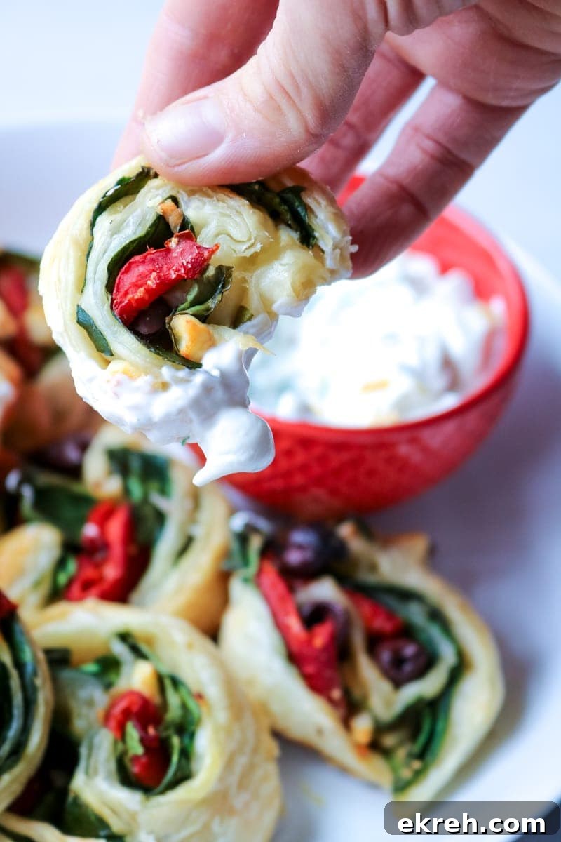 Dipping Greek Roll into Tzatiki Sauce