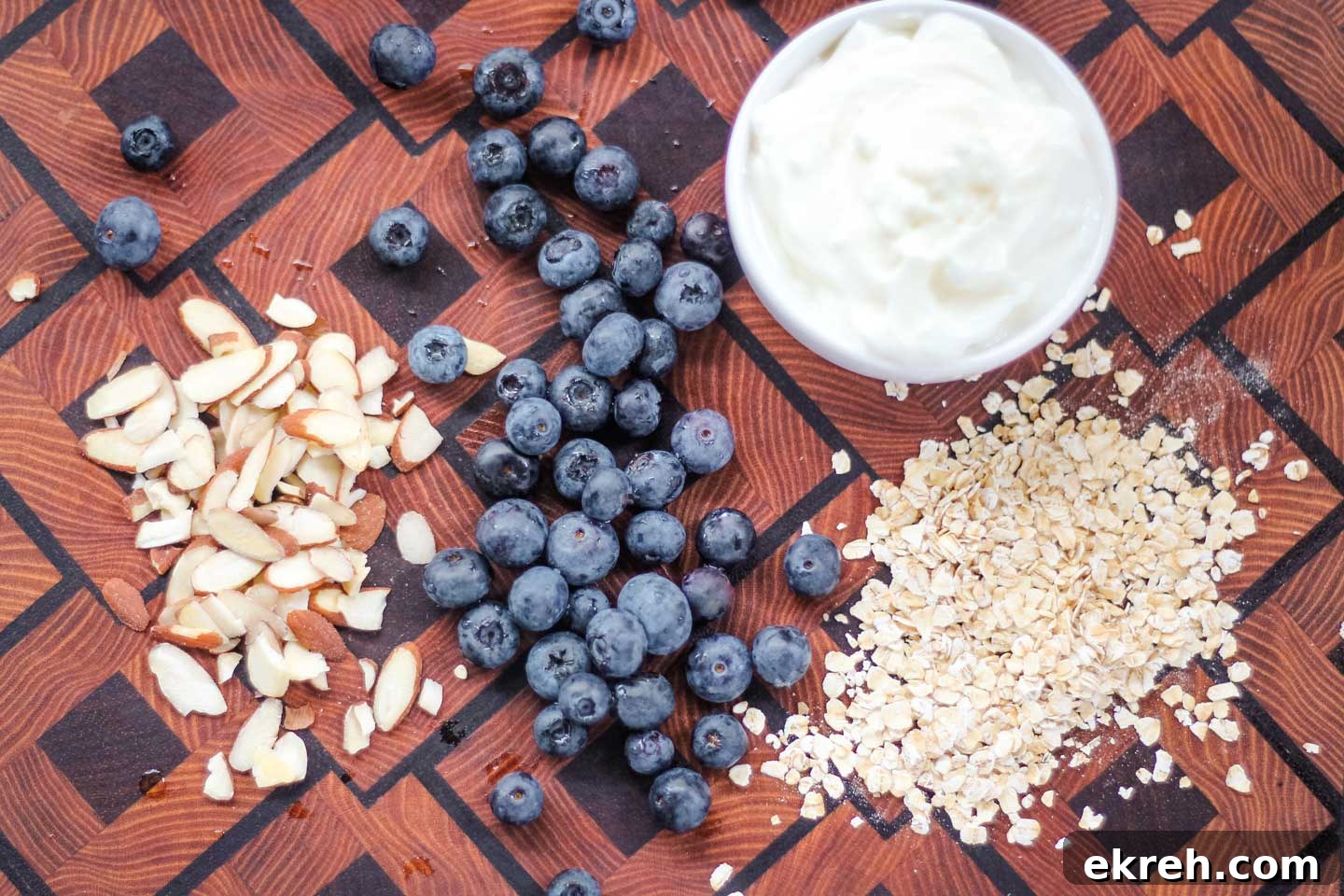 Ingredients for Blueberry Overnight Oats Ingredients for the overnight oats arranged on a board: oats, sliced almonds, blueberries, and Greek yogurt.