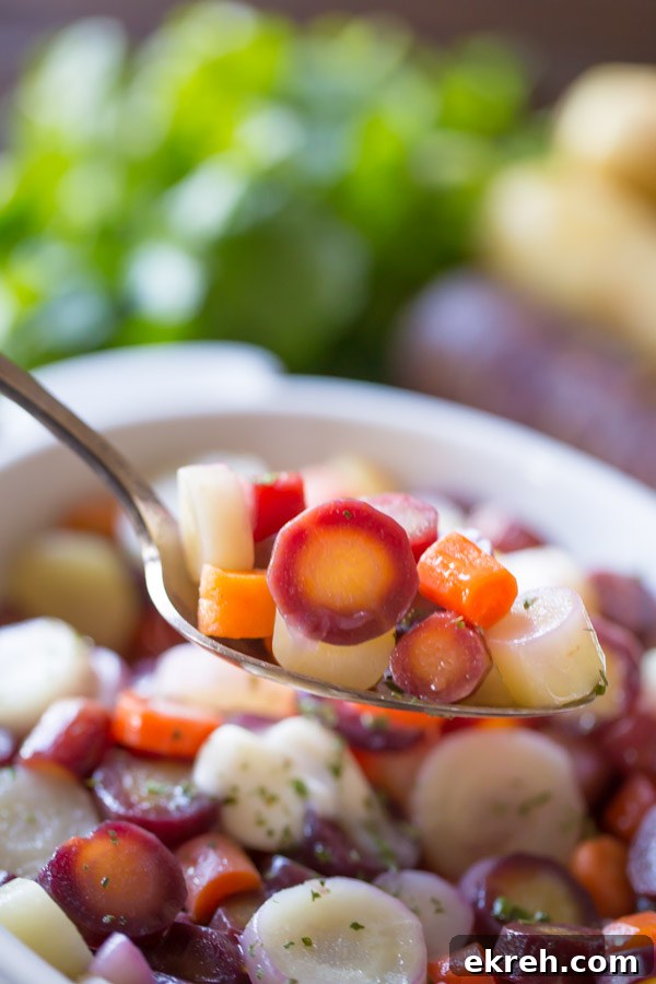 Honey Roasted Rainbow Carrots on a serving spoon held over the serving dish of carrots.