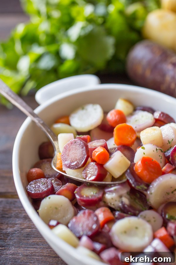 Honey Roasted Rainbow Carrots in a serving dish with a serving spoon in it.