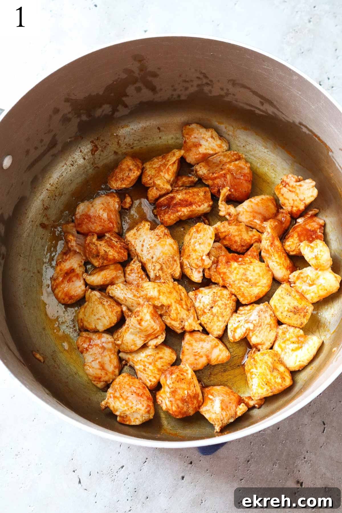 pot with sauteed chicken with salt, pepper, and paprika.