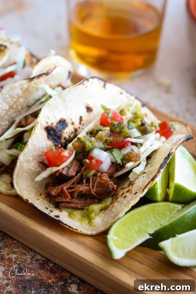 Slow-Braised Spicy Brisket Tacos Recipe 2 braised brisket tacos with cabbage, pico de Gallo, lime wedges