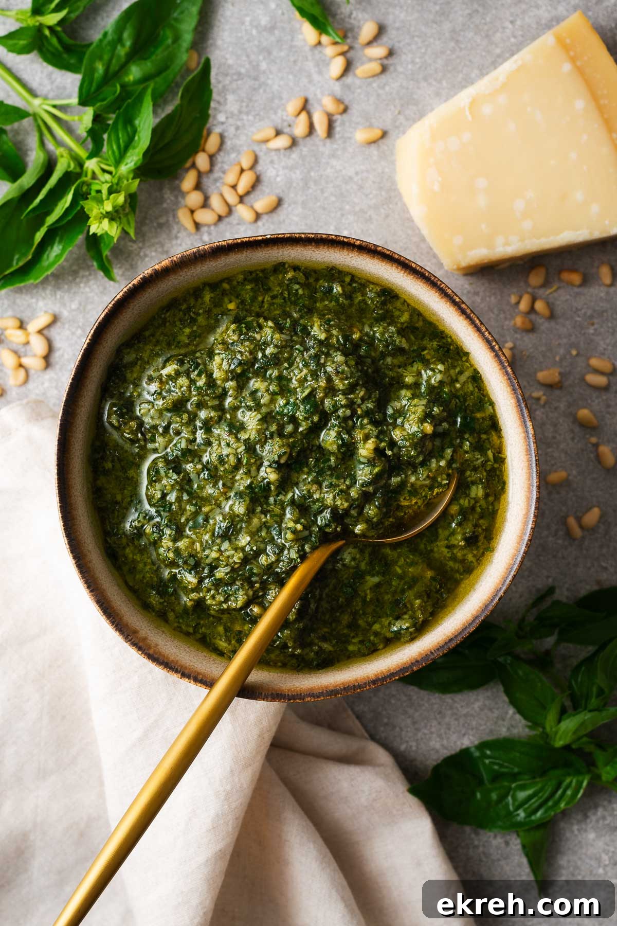 A close-up of a big batch of basil pesto made in a food processor.