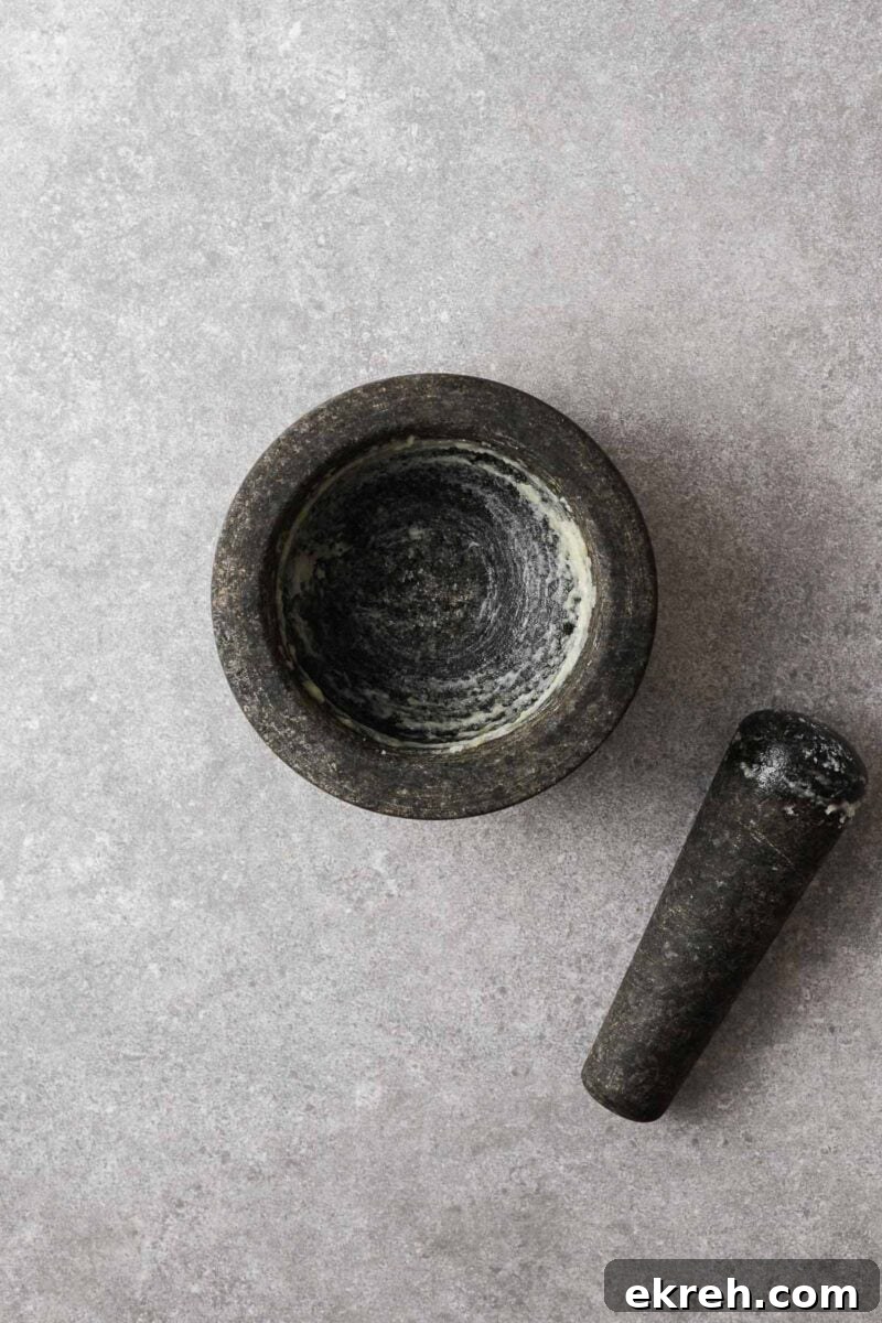 Garlic paste in a mortar made by pounding garlic with coarse sea salt.