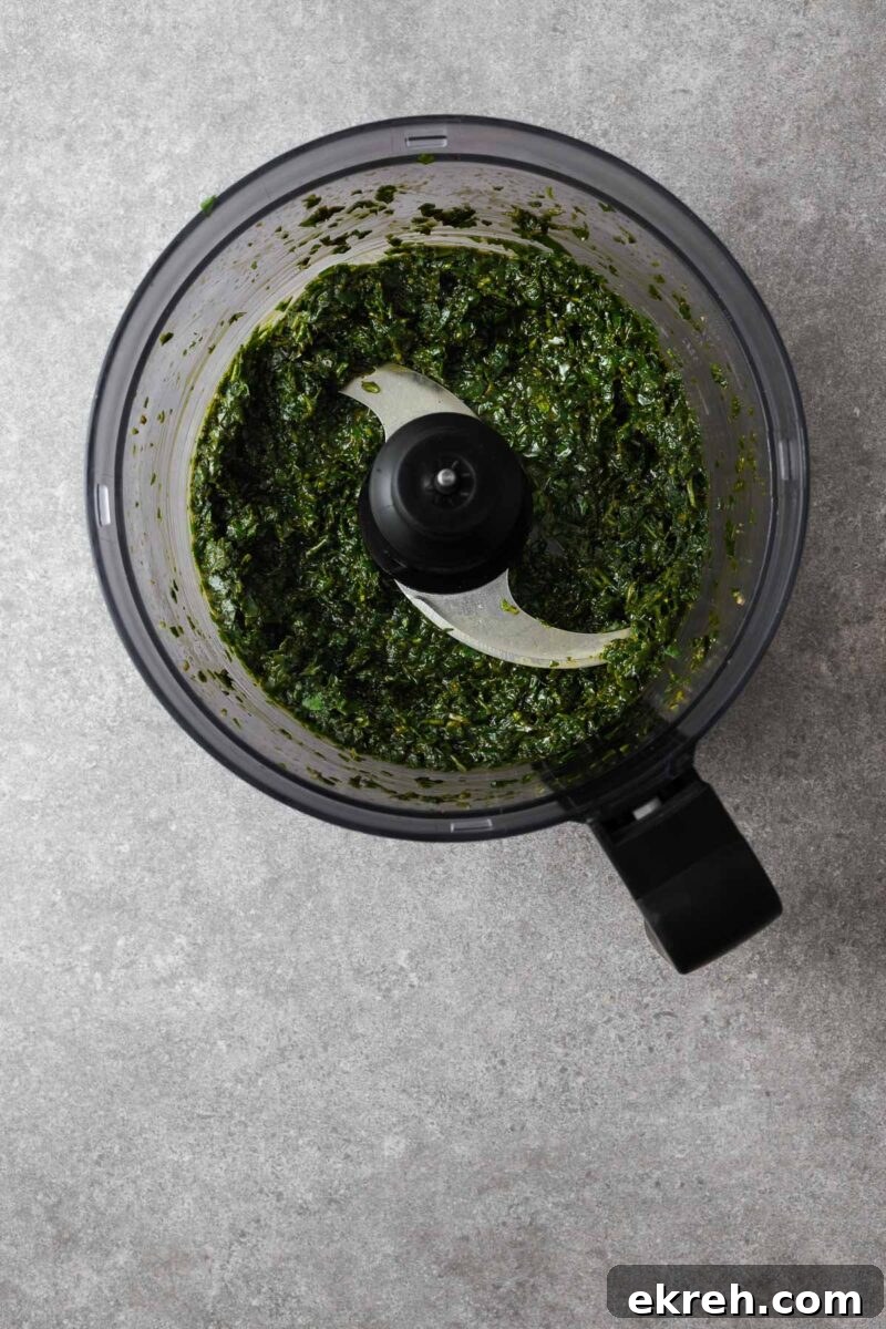 Freshly made basil paste in a food processor bowl.