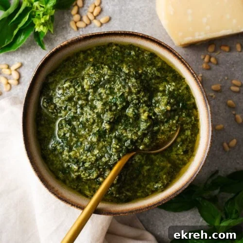 A close-up of a big batch of basil pesto made in a food processor.