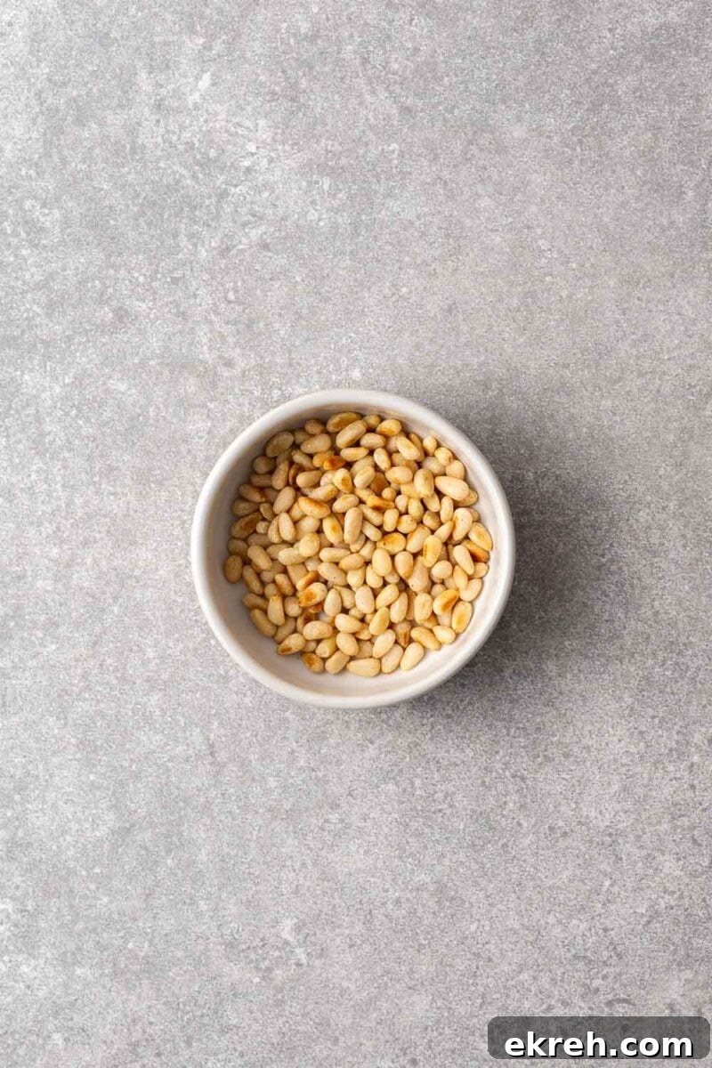 A ceramic bowl with lightly toasted pine nuts.
