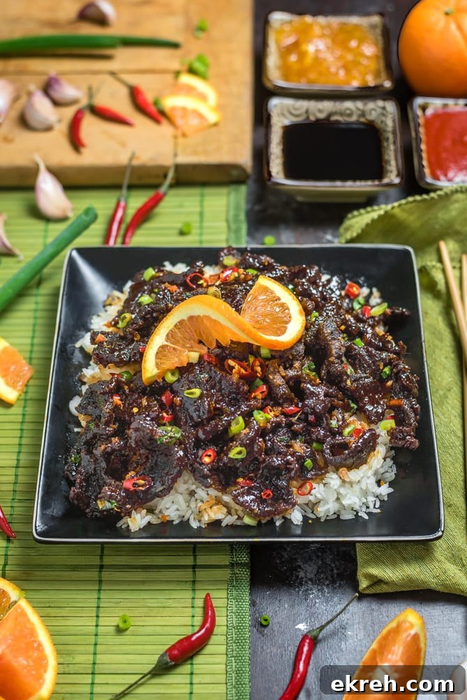 Spicy, Crispy Orange Beef plated with green onions and orange zest.