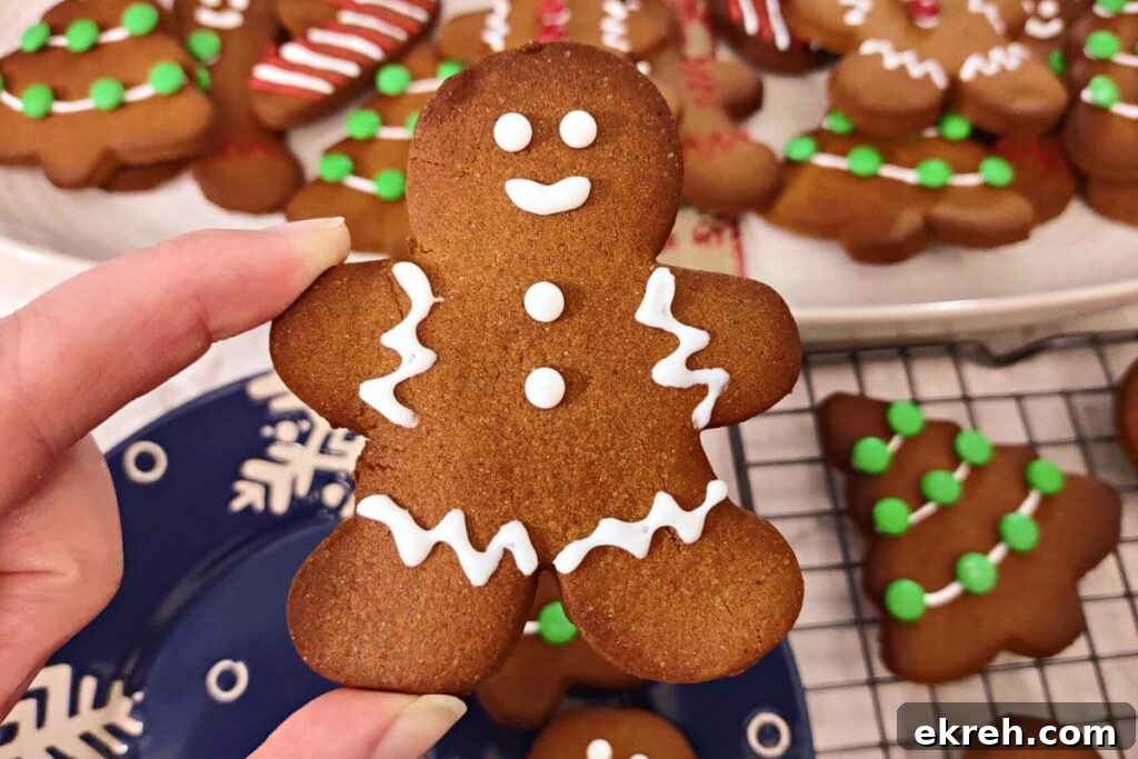 holding up an iced air fryer gingerbread man cookie